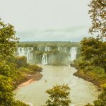 an aerial photography of a waterfalls near the river