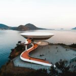 white concrete building beside body of water